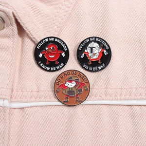 Detailed macro of three enamel pins featuring Ugandan Knuckles memes on pink denim fabric