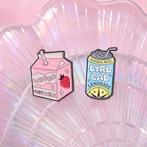 Creative enamel pins featuring pink strawberry milk carton and blue lemonade soda can designs
