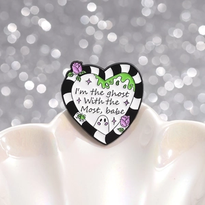 Heart enamel pin with beetlejuice stripes and ghost most text on a pearl dish