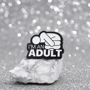 Pin's en émail noir et blanc minimaliste avec message I'M AN ADULT et figurine stylisée