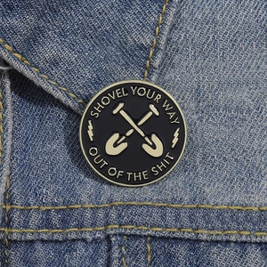 Round enamel shovel lapel pin with gold trim on blue denim jacket pocket