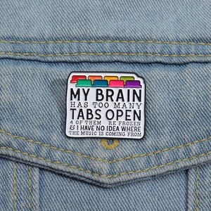 Detail of humor enamel pin with colorful browser tabs on blue denim jacket pocket