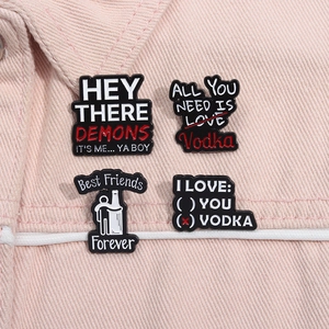 Detail of four creative metal enamel pins with humorous sayings on pink denim background