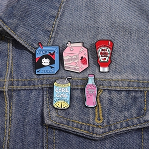 Five-piece set of creative enamel pins featuring cartoon juice and soda designs on denim