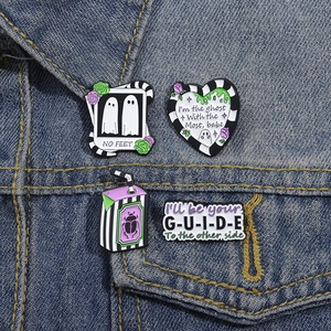 Ghost and beetle enamel pins set with black and white stripes on denim jacket