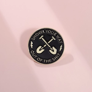 Enamel pin with two crossed shovels and shovel your way out of the shit slogan