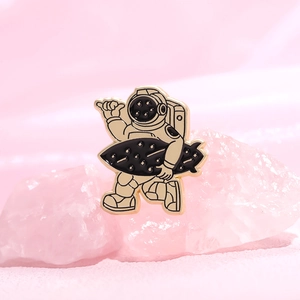 Cartoon astronaut enamel brooch with golden outline on pink crystal display