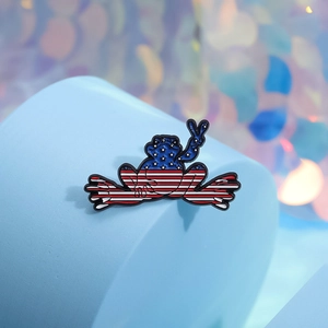 Creative frog enamel pin with American flag pattern making a peace sign on blue stand