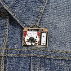 Detail der Emaille-Anstecknadel The Witch Shop auf Jeansjacke mit magischem Design
