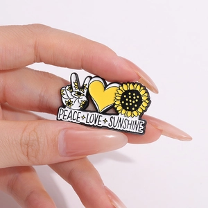 Whimsical frog enamel pin with sunflower and peace sign heart design on hand