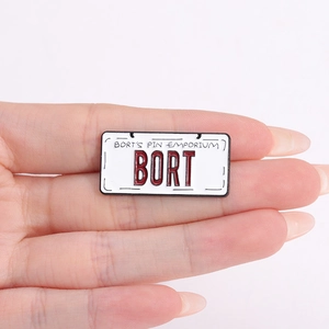 Close-up of a BORT license plate enamel pin with polished metal edges and vibrant finish