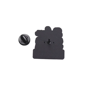 Close-up of black enamel pin back with rubber clutch fastener and metal fixing pin