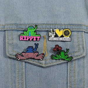 Set of 4 frog and sunflower enamel pins pinned on a light blue denim jacket pocket