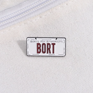 Detailed macro view of the BORT license plate enamel pin on a white canvas texture