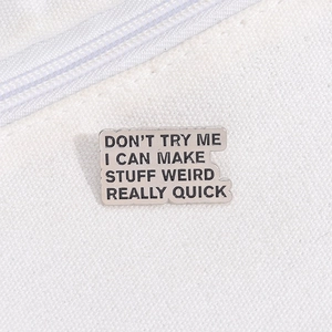 Macro detail of metal enamel badge with funny quote on white canvas fabric bag background