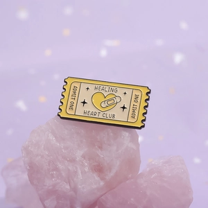 Pin's émaillé Healing Heart Club en forme de ticket sur un fond de cristal rose