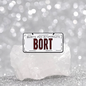 Retro BORT license plate enamel pin badge on white crystal stone with bokeh background