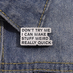 Creative enamel letter brooch with English phrase on blue denim background
