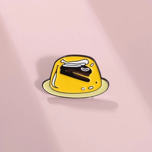 Cute yellow jello enamel pin with stapler detail on pink background for clothing decor
