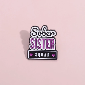 Creative enamel pin with Sober Sister Squad text and purple hearts on pink background