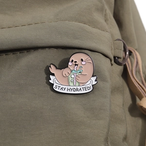 Cute enamel seal pin drinking bubble tea on backpack with Stay Hydrated slogan