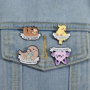 Detailed set of four cute cartoon animal enamel pins featuring a sloth and cockatiel on denim