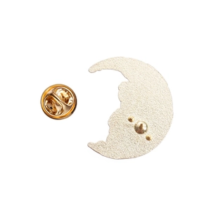 Close-up of golden moon-shaped enamel pin back with a butterfly clutch fastener