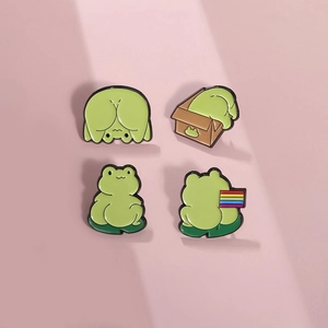 Set de cuatro bonitos pines de esmalte de ranas verdes con bandera arcoíris en fondo rosa