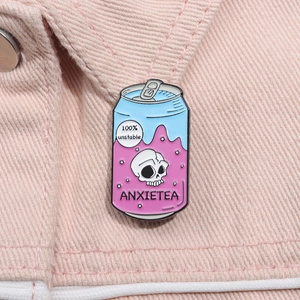 Détail du pin's émaillé canette de soda avec crâne sur tissu denim rose vif