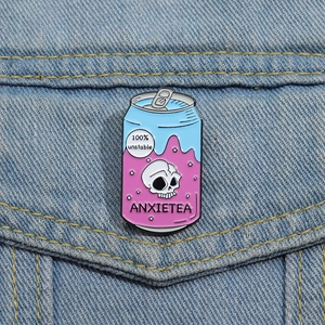 Détail du pin's émaillé canette rose avec crâne et texte Anxietea sur veste jean