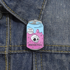 Détail de l'épingle en émail Anxietea en forme de canette sur une veste en jean
