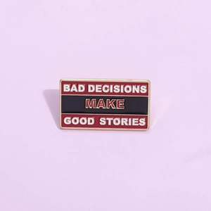 Enamel lapel pin badge featuring the text BAD DECISIONS MAKE GOOD STORIES in bold colors