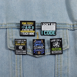 Détail de cinq pin's science et codage sur une poche de veste en jean bleu clair