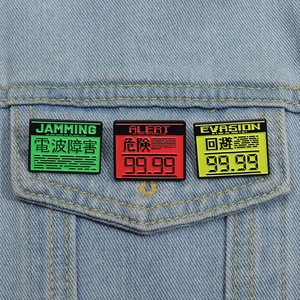 Trois pin's émaillés colorés style jeu vintage sur une poche de veste en jean
