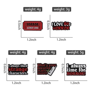 Macro view of horror themed enamel pins showing detailed dimensions and weight specifications