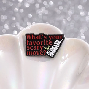 Enamel scary movie quote brooch with red lettering and vintage phone on white shell tray