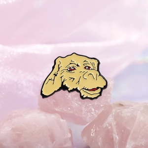Falkor Luck Dragon enamel pin on a pink quartz stone background for backpacks
