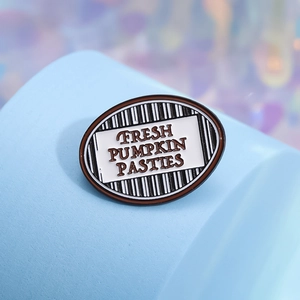 Oval enamel brooch with Fresh Pumpkin Pasties text on striped background