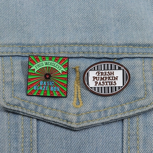 Detailed enamel pins on denim jacket featuring Wizarding World inspired Fred Weasley theme