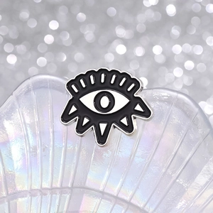 Detailed view of the dark devil eye enamel brooch with metallic luster on iridescent shell