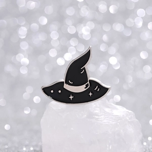 Detail of wizard hat enamel pin with stars and crescent moon on white crystal
