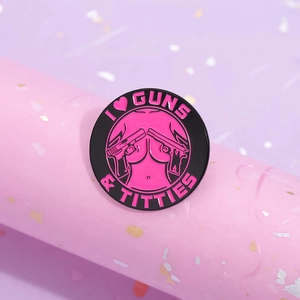 Creative round enamel pin featuring black and pink contrast with I Love Guns & Titties text