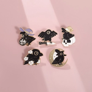 Macro view of five-piece black crow enamel pin set with gothic and Halloween theme elements