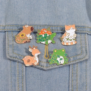 Set of 5 enamel pins featuring capybara, turtle, cat, and frog on denim jacket pocket
