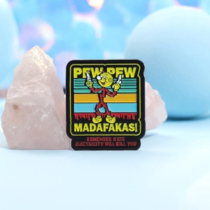 Black enamel cartoon pin with yellow Pew Pew text and colorful decorative props