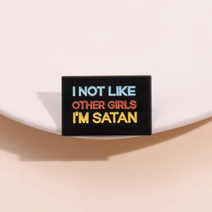 Minimalist rectangular enamel pin featuring colorful Satan quote on black background