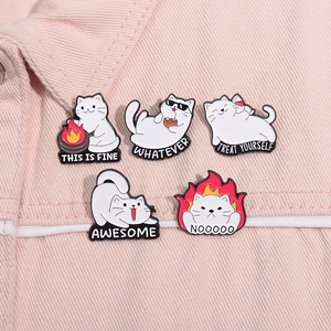 Details von fünf süßen Emaille-Katzenpins mit lustigen Sprüchen auf rosa Denim