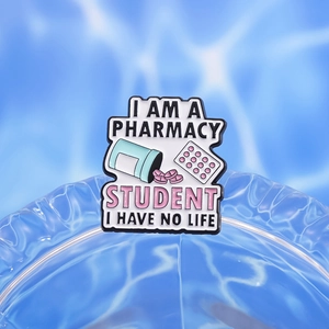 Enamel pharmacy student brooch with blue pill bottle and pink pills on water ripple background