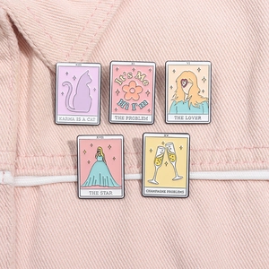 Lot de cinq pin's tarot en émail pastel avec paroles sur tissu denim rose