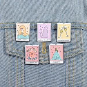 Détail de broches en émail de style tarot avec paroles de chansons sur une veste en jean
